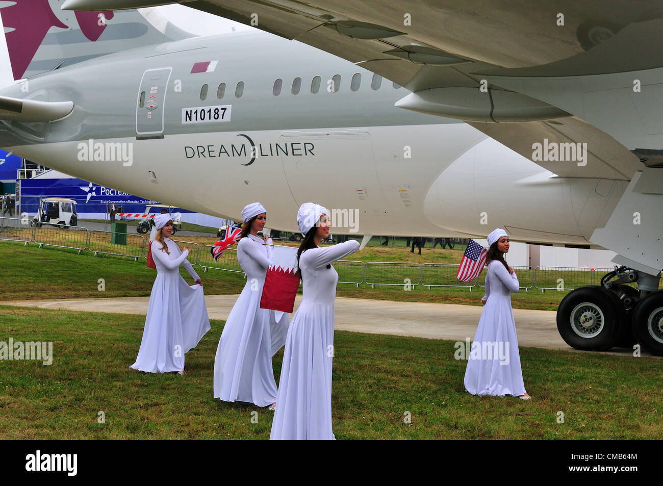 Farnborough, UK. Monday 9th July 2012.  Qatar Airways dancers dance around the US Plane maker Boeing 787  jet ‘Dreamliner’ at the Farnborough International Airshow 2012 which started today. It is seen as a rival to European Airbus at the Farnborough air show. Qatar Airways participated for the first time in flying displays at the Farnborough International Airshow. Stock Photo