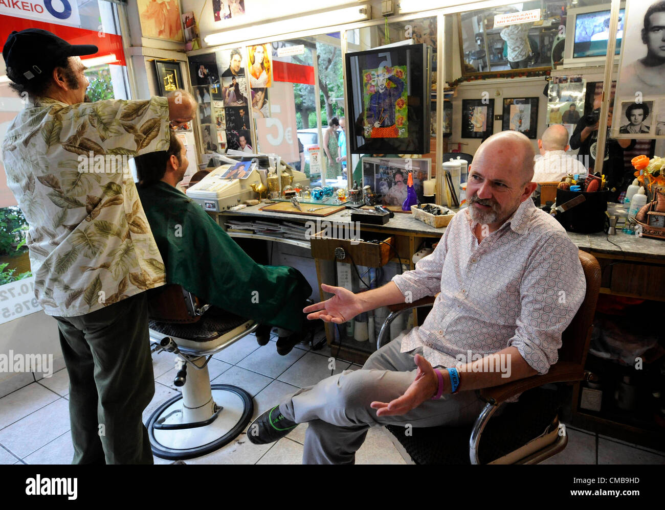 July 09, 2012. Athens, Greece. Exhibition Opening at Stathis-Laura Barbershop. British artist Nicholas Moore, who now lives on Syros in Greece, has joined the “12 Artists 12 Barbershops” exhibition in Athens, Greece. The barbershop is probably second only to the Taverna as the venue for debate in Greece and his evocative art is bound to give the barbershop clients something to discuss during July. Stock Photo