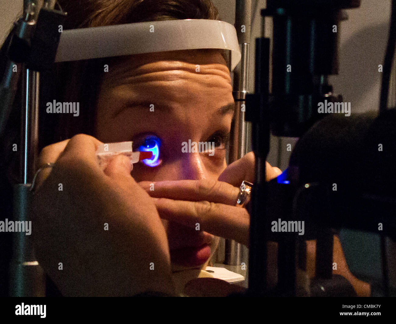Young female teenager undergoes an eye exam by a licensed optometrist ...