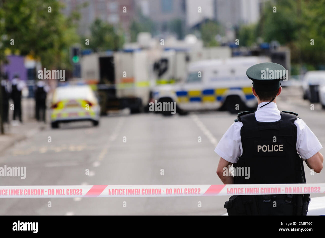 Belfast, Northern Ireland. 13/07/2013 - Police officer from the PSNI stands guard at a Police cordon point while army ATOs from the Royal Logistics Corp deal with a suspect bomb. Stock Photo
