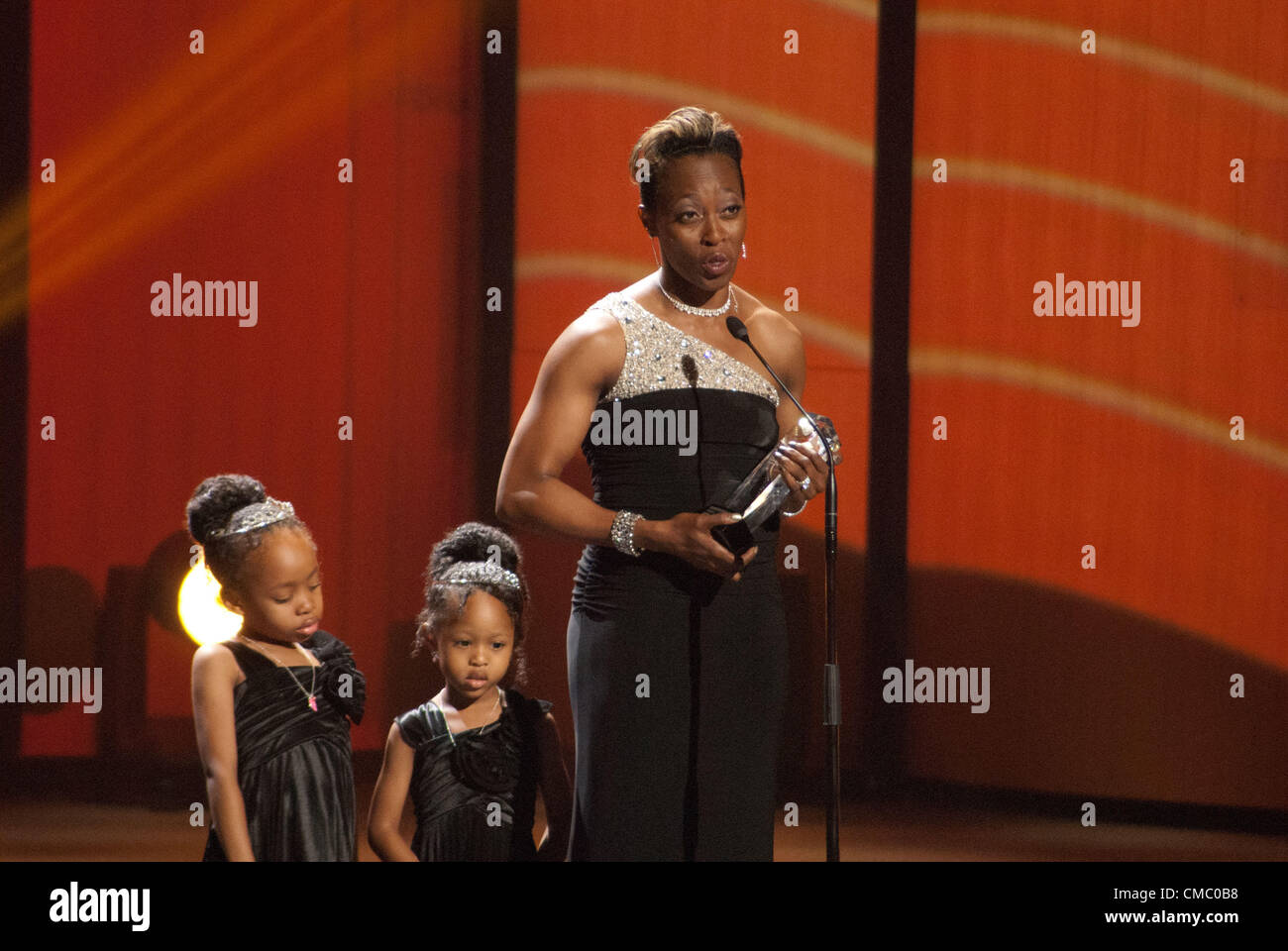 Gail Devers on stage with her daughters Karsen and Legacy, accepts the inductee award for the U