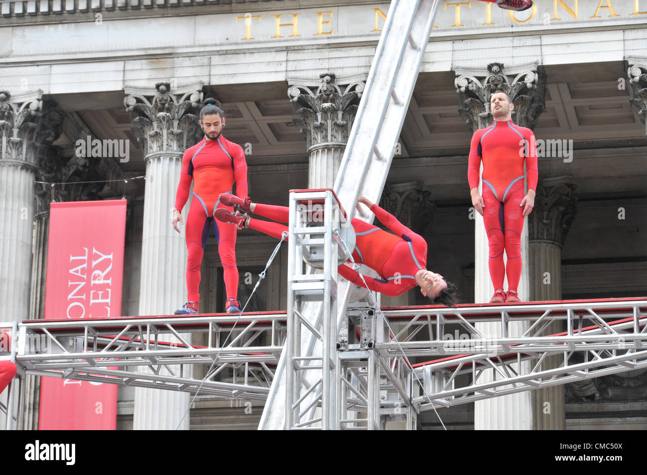 London, UK. 15th July 2012. Performers on the spinning ladder. One Extraordinary Day, Surprises: Streb. Choreographer Elizabeth Streb and her New York dance company 'Action Heroes' with their performance ASCENSION in front of the National Gallery. Stock Photo