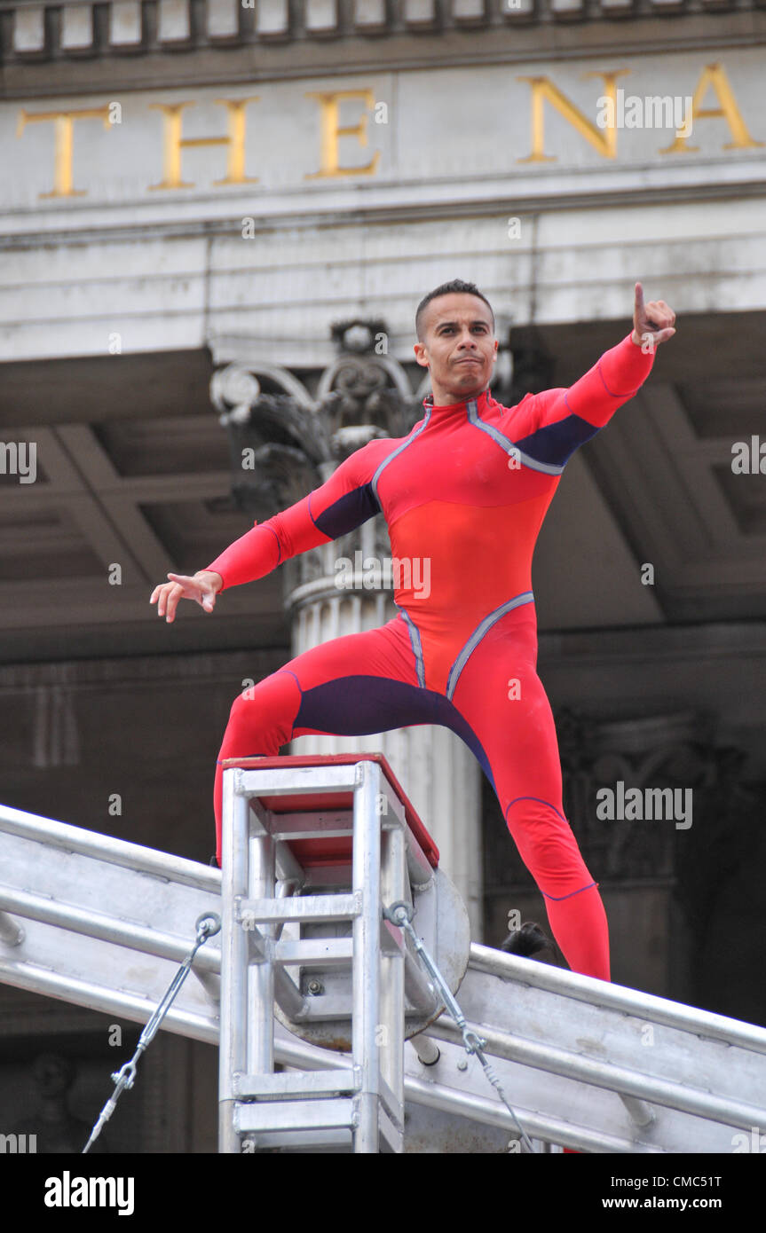 London, UK. 15th July 2012. A performer points to the crowd. One Extraordinary Day, Surprises: Streb. Choreographer Elizabeth Streb and her New York dance company 'Action Heroes' with their performance ASCENSION in front of the National Gallery. Stock Photo