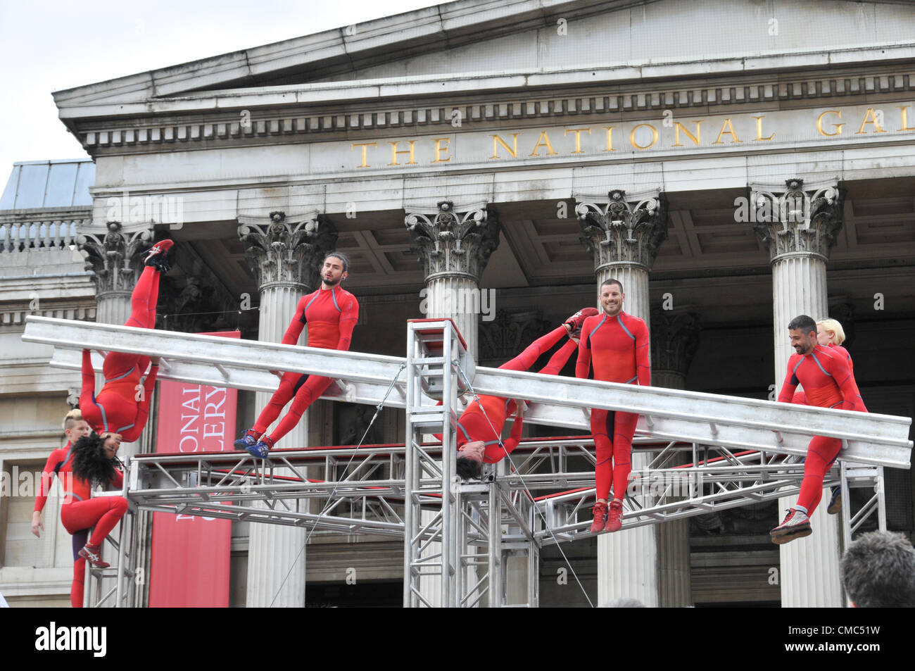 London, UK. 15th July 2012. The performers on the spinning ladder. One Extraordinary Day, Surprises: Streb. Choreographer Elizabeth Streb and her New York dance company 'Action Heroes' with their performance ASCENSION in front of the National Gallery. Stock Photo