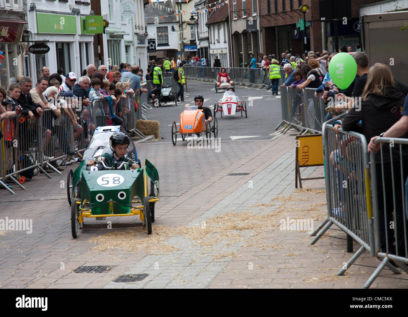 Participants take part in the British Pedal Car Grand Prix 2012. The 'wacky races' event was held on closed roads in the town. Stock Photo