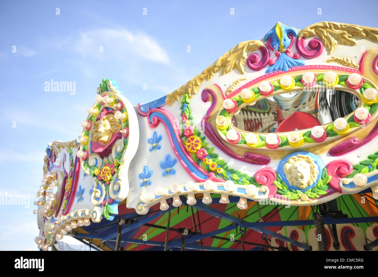Carousel or Merry-Go-Round colorful pastel ornate Top closeup with blue sky Stock Photo