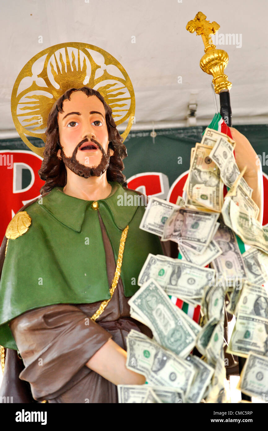 At the Feast of St. Rocco, the Statue of San Rocco has money on ribbons streaming from his staff, on July 14, 2012, in Oyster Bay, New York, USA. Proceeds from this booth will be donated to St. Dominic Church. The Italian American Citizens Club of Oyster Bay organized the five-day festival, which ends July 15, to promote Italian-American heritage. Stock Photo