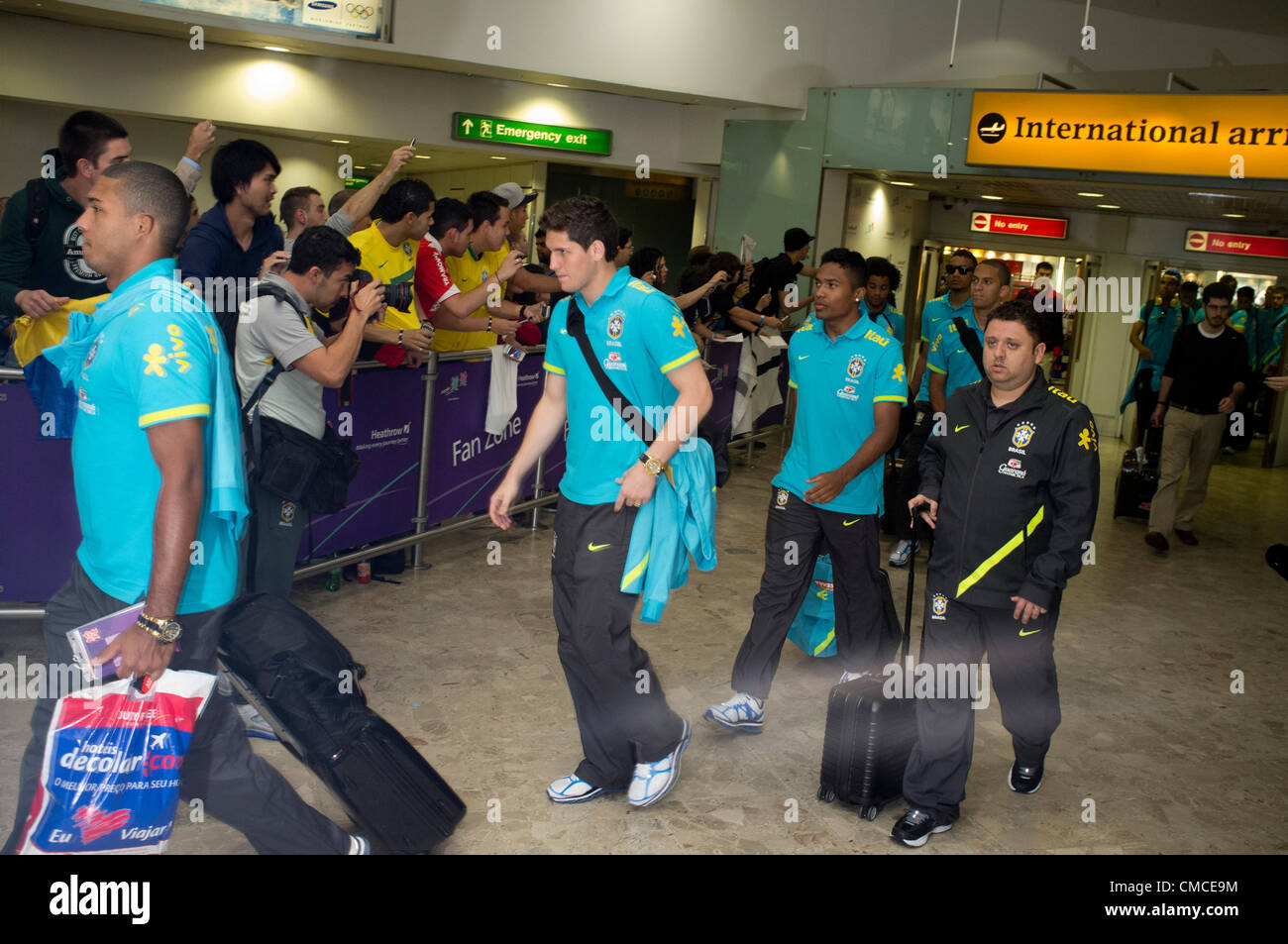 17th July 2012.  London Heathrow, UK.  Olympic Competitors and Officials arrive at Heathrow airport terminals. The Brazil Olympic Football team emerge from the airport terminal building with Police security . Stock Photo