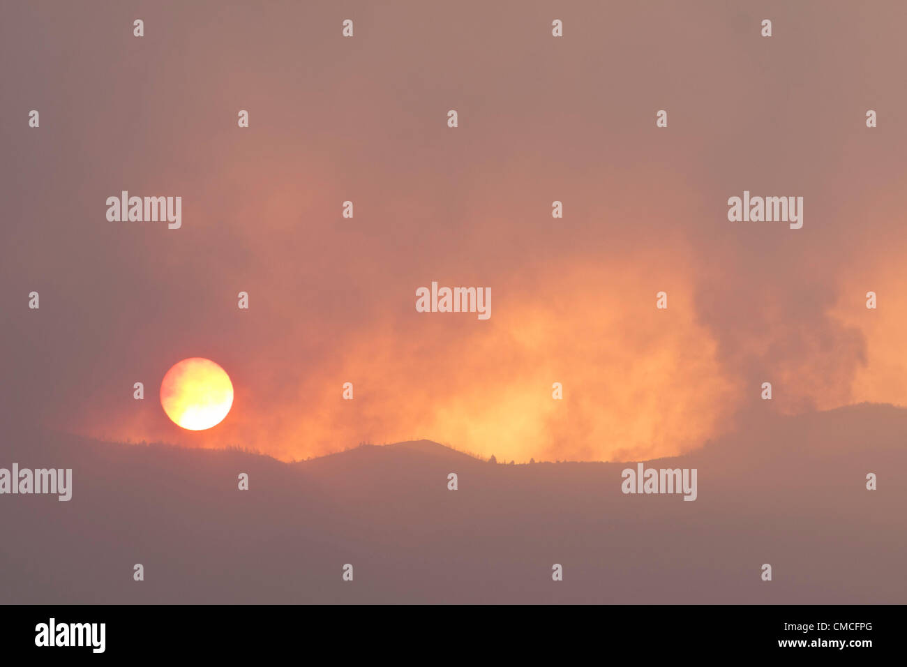Tenerife, Canary Islands. 18th July, 2012. Sunrise through the smoke of the forest fires on the fourth day since they began, seen from Playa San Juan, Guia de Isora, Tenerife, Canary Islands, Spain. Stock Photo