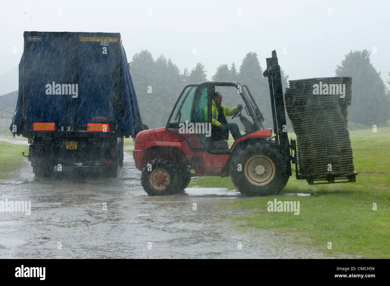 July 18th 2012. Builth Wells, Wales, UK. Workers prepare a car park for the Royal Welsh Showground. Organisers are optimistic for fine weather next week when The Royal Welsh Show starts on Monday 23rd July 2012. Stock Photo