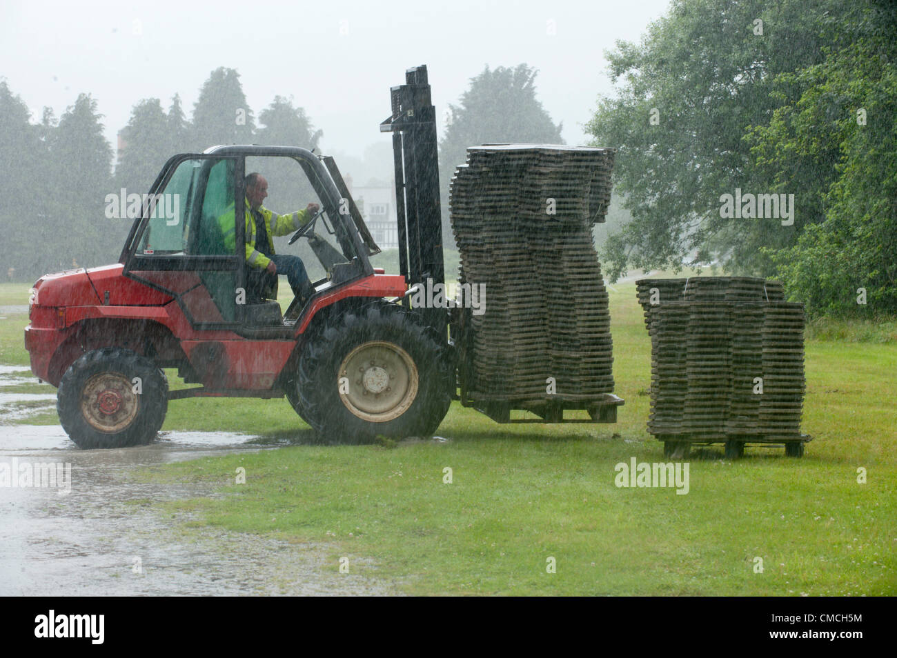 July 18th 2012. Builth Wells, Wales, UK. Workers prepare a car park for the Royal Welsh Showground. Organisers are optimistic for fine weather next week when The Royal Welsh Show starts on Monday 23rd July 2012. Stock Photo