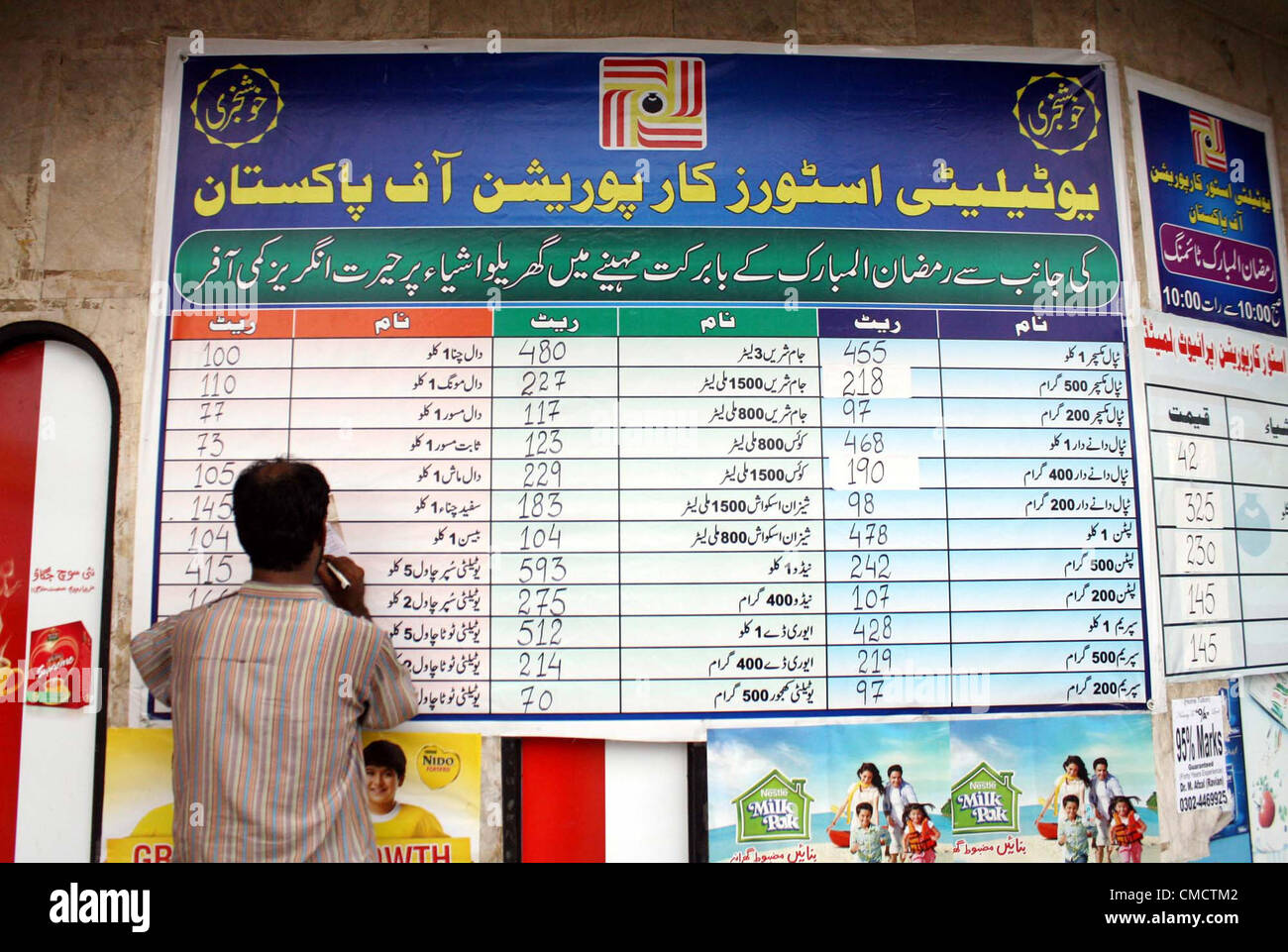 A man checks consumer subsidies price list at a utility store due to