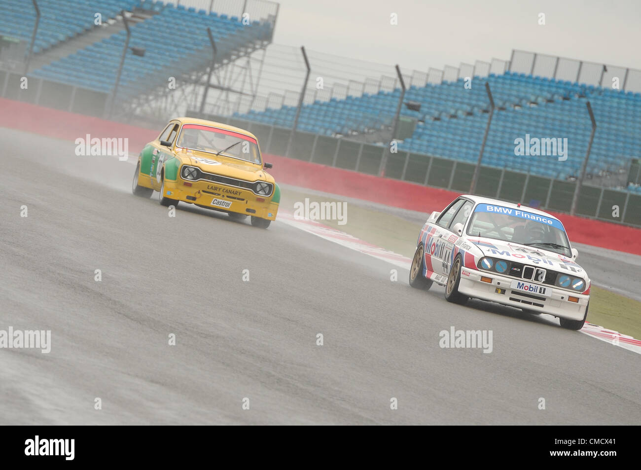20th July 2012, Silverstone, UK  David Cuff and Mark Smith's BMW E30 M3, and Michael Bell's Ford Escort in the rain during qualifying for the Fujifilm Touring Car Trophy 1970-2000 race at Silverstone Classic 2012 Stock Photo