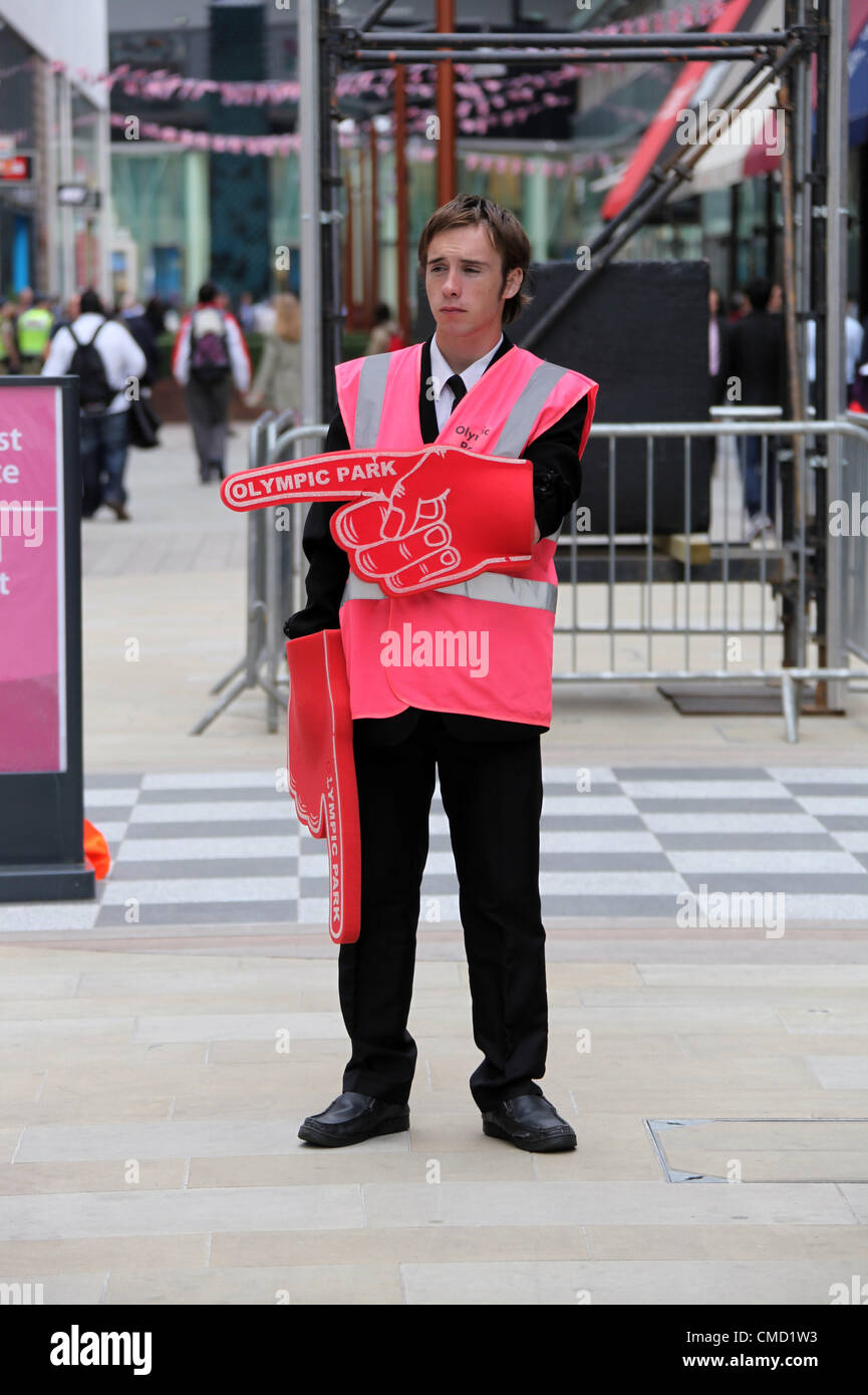 A steward giving directions to the Olympic Park using gigantic pink