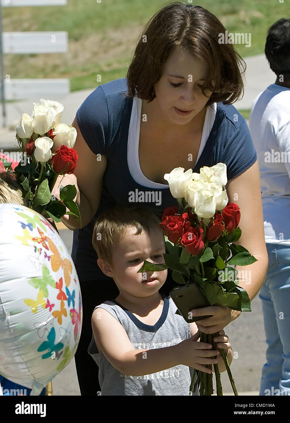 July 21, 2012 - Aurora, CO, USA - 3 yr. old DEVON AMMON, bottom, and his Mom LYNDSAY, top, contribute to a memorial on the corner of E. Centerpoint Dr. & So. Sable Blvd. in honor of all who were killed and wounded during the mass shooting at the Century 16 movie theater on Thursday night. The memorial is across the street from the theater. (Credit Image: © Hector Acevedo/ZUMAPRESS.com) Stock Photo