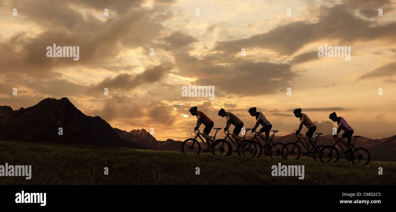 08.11.2011. Germany. Model released picture of cyclists riding into the setting sun. Stock Photo