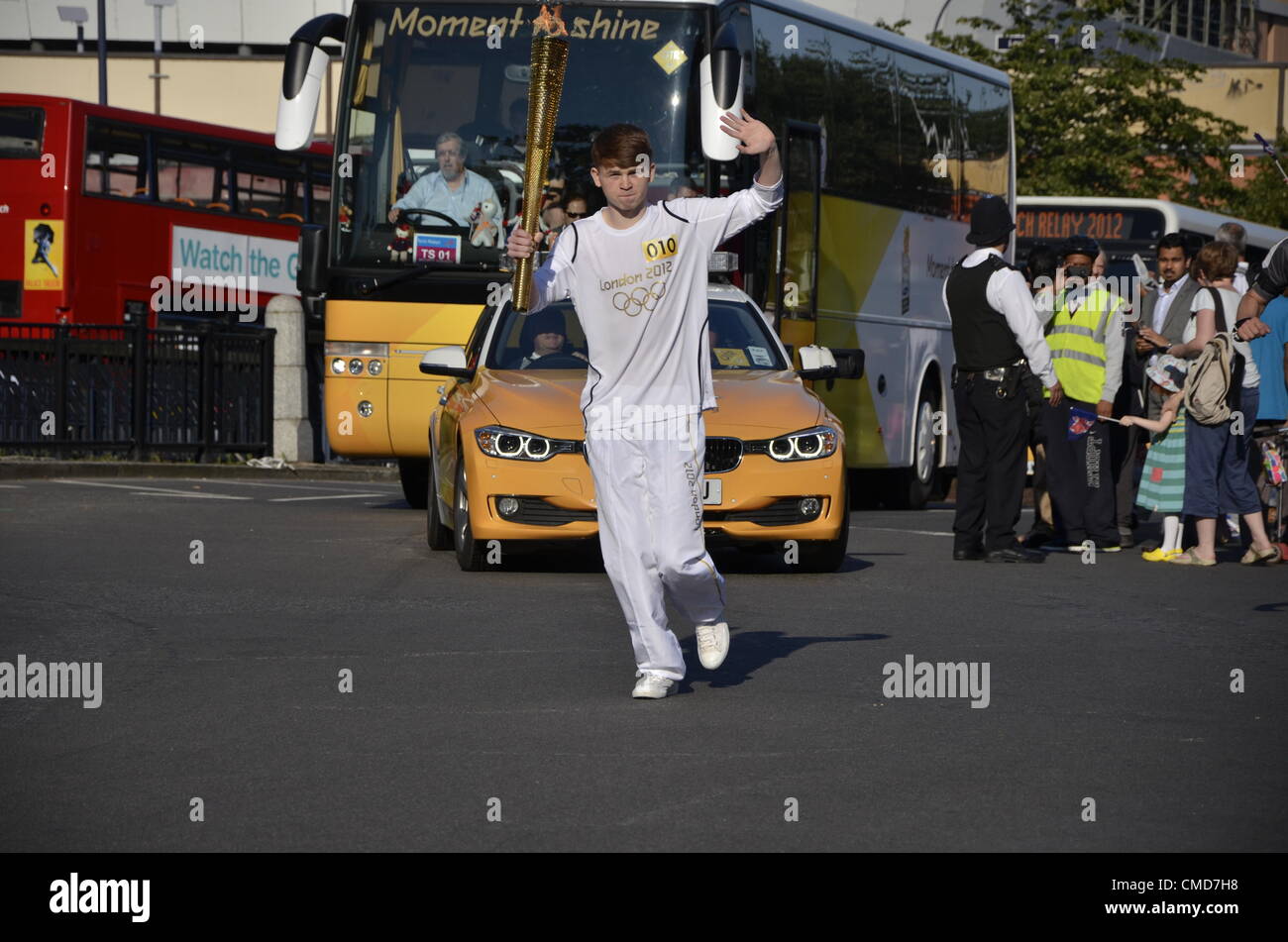 Lewisham, London, UK. Wednesday 23rd July 2012. Daniel Gee carries the Olympic torch through Lewisham High Street. Stock Photo