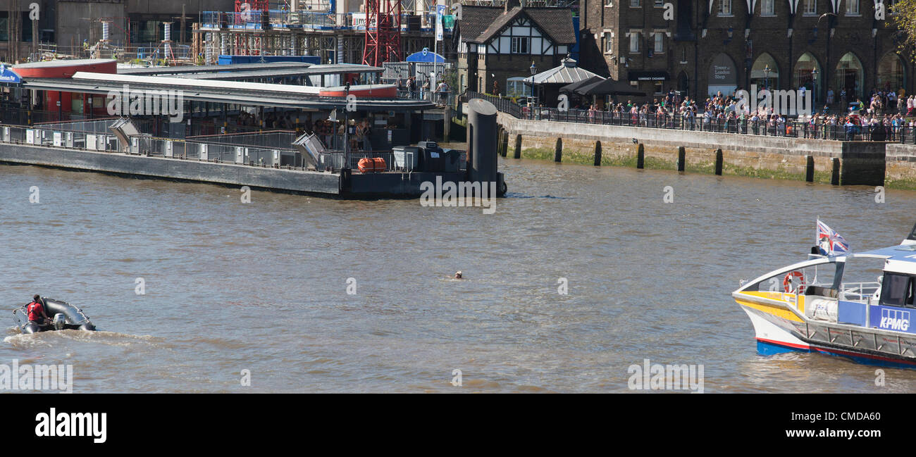 London, England, UK. Monday, 23 July 2012. A man today, Monday 23rd July, dived off Tower Bridge into the River Thames and went for a swim. He was quickly captured by police and arrested. As he was taken away in a police dinghy, he waved to spectators, apparently unharmed. Stock Photo