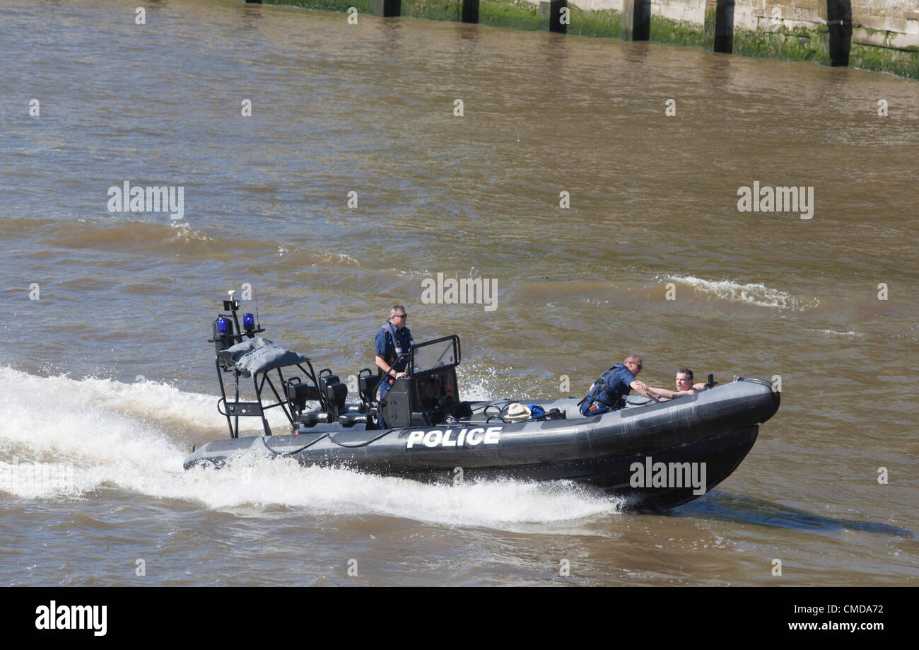 London, England, UK. Monday, 23 July 2012. A man today, Monday 23rd July, dived off Tower Bridge into the River Thames and went for a swim. He was quickly captured by police and arrested. As he was taken away in a police dinghy, he waved to spectators, apparently unharmed. Stock Photo