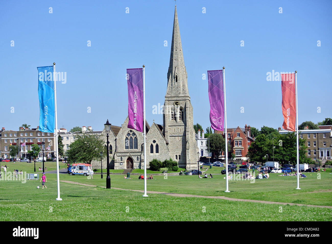 Blackheath, London, UK. 23rd July 2012. Olympic Games Preparations in Blackheath - 2012 Olympics flags and All Saints Church. Blackheath will be the site for a big screen.  Stock Photo