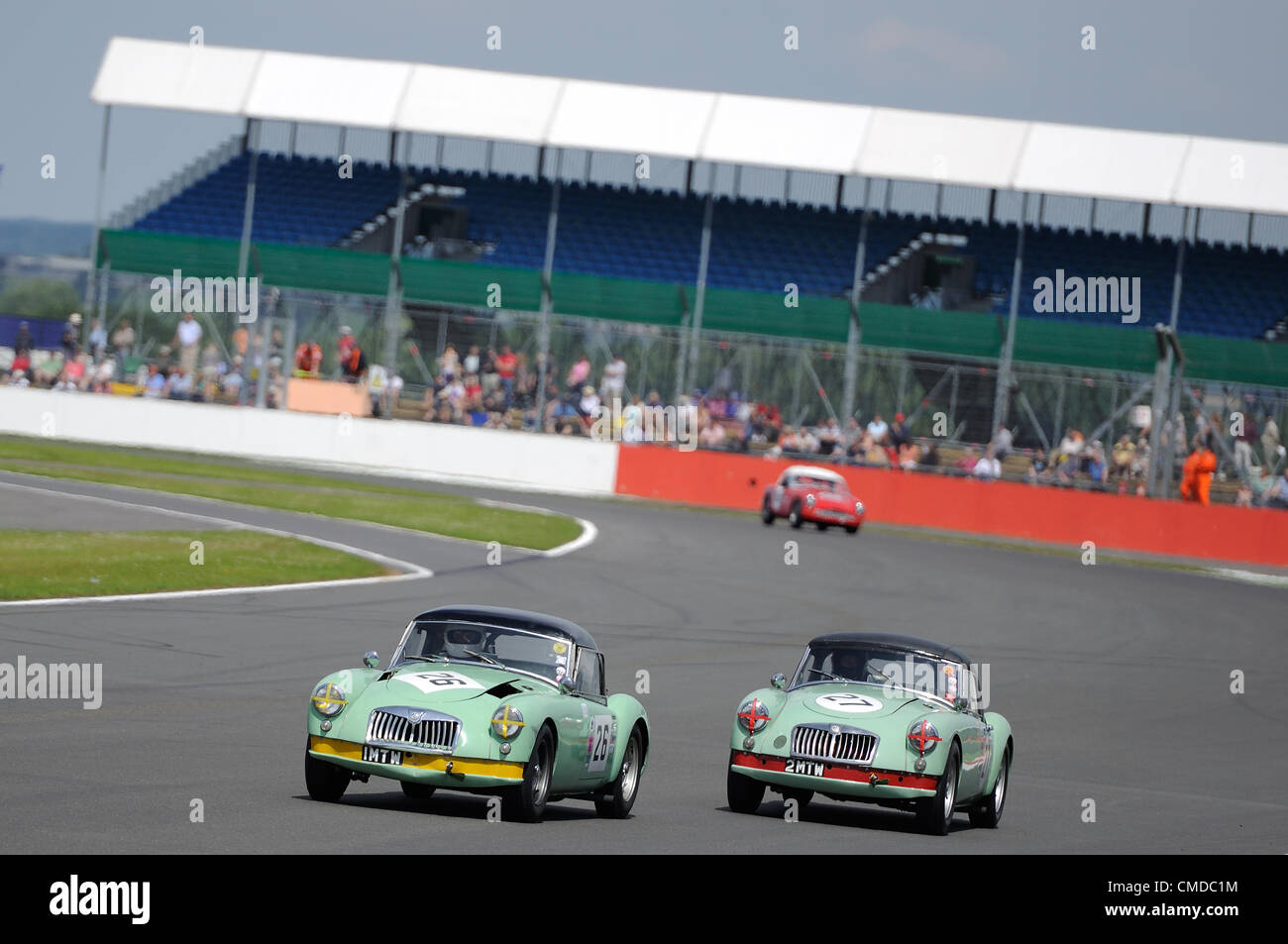 22nd July 2012, Silverstone, UK.  The two MGA Twincams of Mark Daniell & Matthew Moore and Roger Daniell & Mark Daniell battle for position during the Royal Automobile Club Tourist Trophy for Historic Cars (Pre-63GT) race at Silverstone Classic 2012 Stock Photo