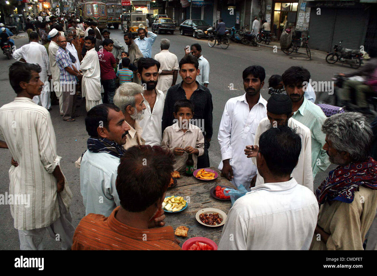 Faithful Muslims break their fast during Iftari (breaking fast  meal) the Holy month of Ramadan-ul-Mubarak at Burns road in Karachi on Tuesday, July 24,  2012. Stock Photo