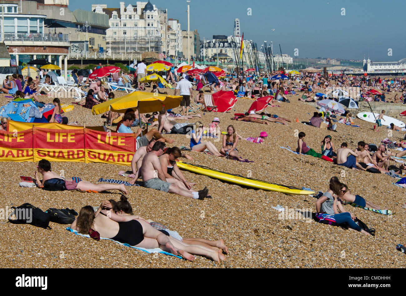 Enjoying the summer sun on Brighton Beach Stock Photo - Alamy