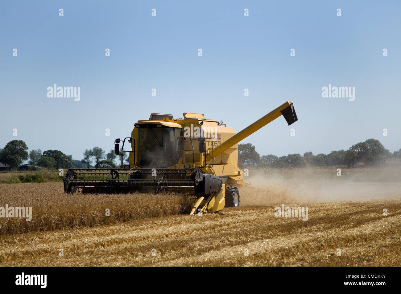 New Holland TX63 combine harvester combing Barley in Norfolk,UK against a  blue summer sky Stock Photo - Alamy