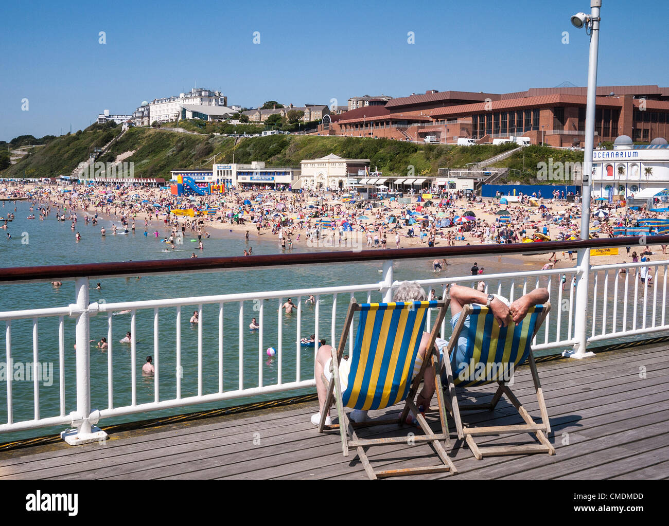 Bournemouth, Couple relaxing in deck chairs on the Pier, overlooking a