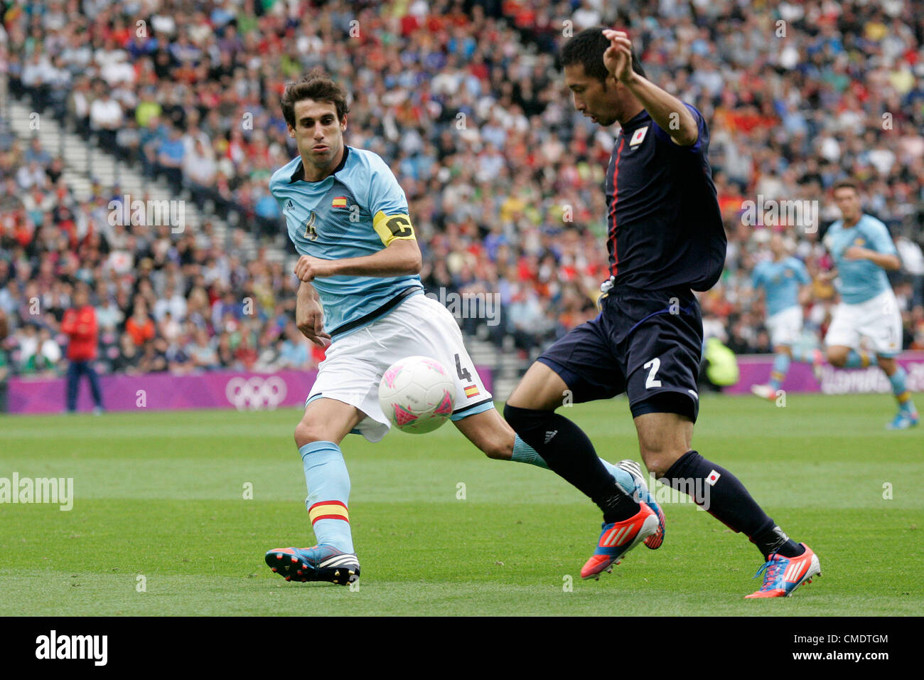26.07.2012 Glasgow, Scotland. 4 Javi Martínez and 2 Yuhei Tokunaga in action during the Olympic Football Men's Preliminary game between Spain and Japan from Hampden Park. Japan pulled off a shock win over Spain by a score of 1-0. Stock Photo