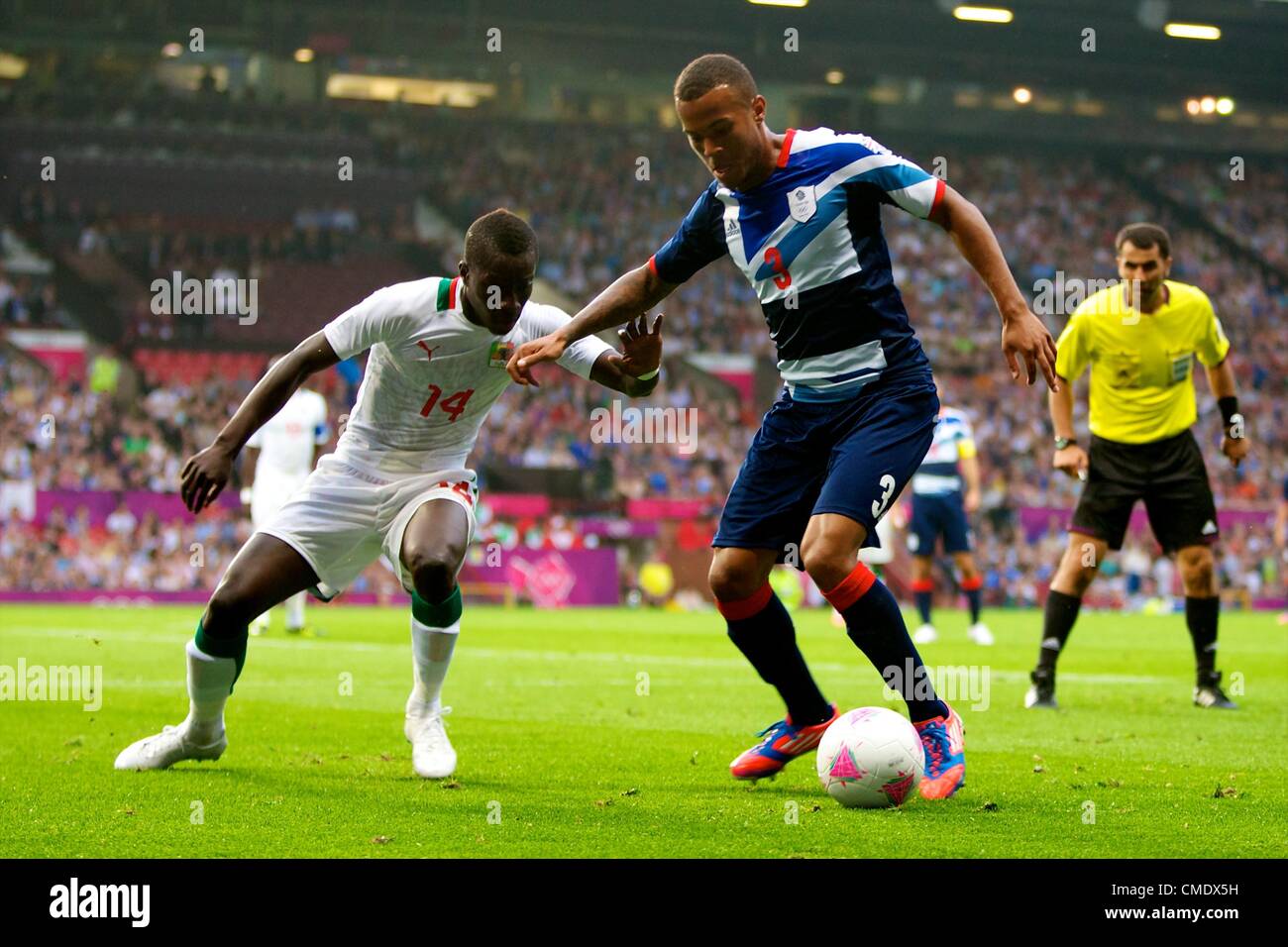 26.07.2012 Manchester, England. Team GB defender Ryan Bertrand and Senegal midfielder Idrissa Gueye in action during the first round group A mens match between Team GB and Senegal. Stock Photo