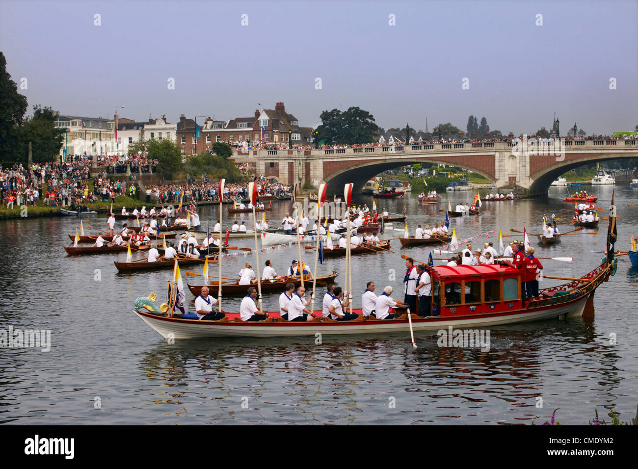 Friday 27 July, 2012. Flotilla of boats on River Thames at Hampton Court Bridge, waiting to follow the Olympic flame downstream to London. England. Credit:  Cephas Picture Library / Alamy Live News. Stock Photo
