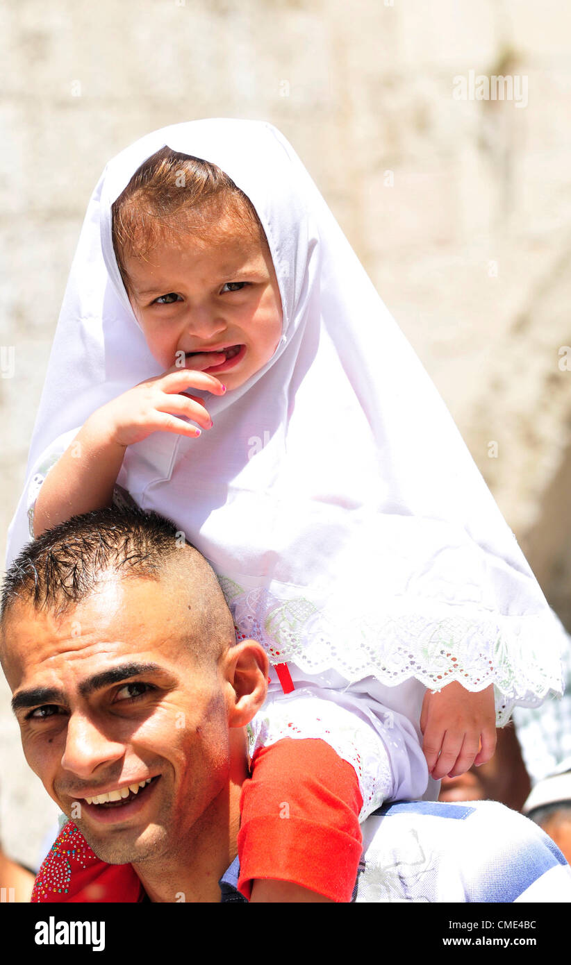 Father and his daughter leaving the Al Aqsa mosque after the 2nd Friday prayers of the holy Ramadan month. Stock Photo