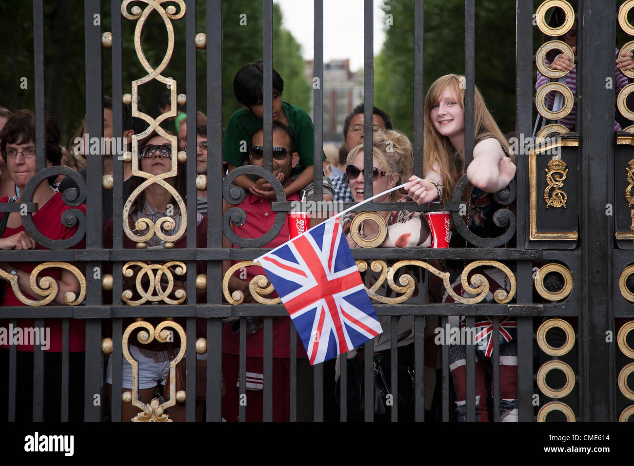 Spectators watch the Men's Olympic Cycling Road Race through Green Park's Royal Gates in London on 28 July 2012. The race, which passed by Buckingham Palace to the finish line on The Mall, was won by Alexander Vinokourov of Kazakhstan Stock Photo