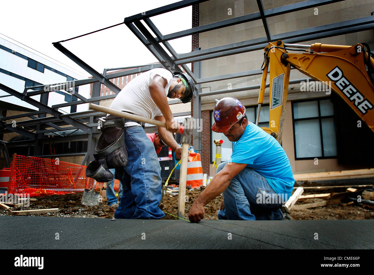 July 27, 2012 - Memphis, TN, U.S. - July 27, 2012 - Construction workers Cesar Arellano (left) and Juan Rodriquez (rigth) pound in a wooden maker as they prepare to lay concrete as part of a new driveway and awning at The Regional Medical Center of Memphis Friday morning. The Med board recently approved a $32.4 million plan to finish out floors in Turner Tower, which will allow the hospital to become more competitive in attracting paying patients. (Credit Image: © Mark Weber/The Commercial Appeal/ZUMAPRESS.com) Stock Photo