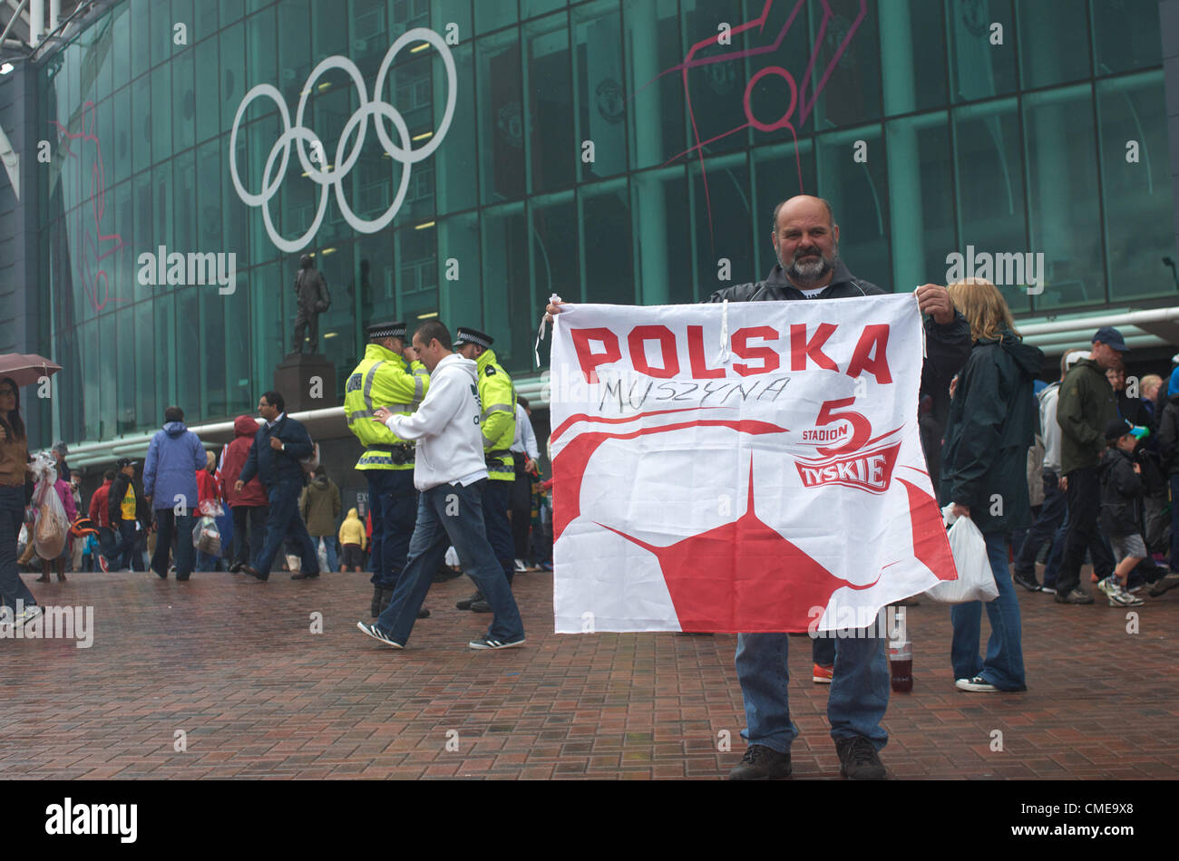 A Polish fan poses outside Old Trafford, Manchester United's ground