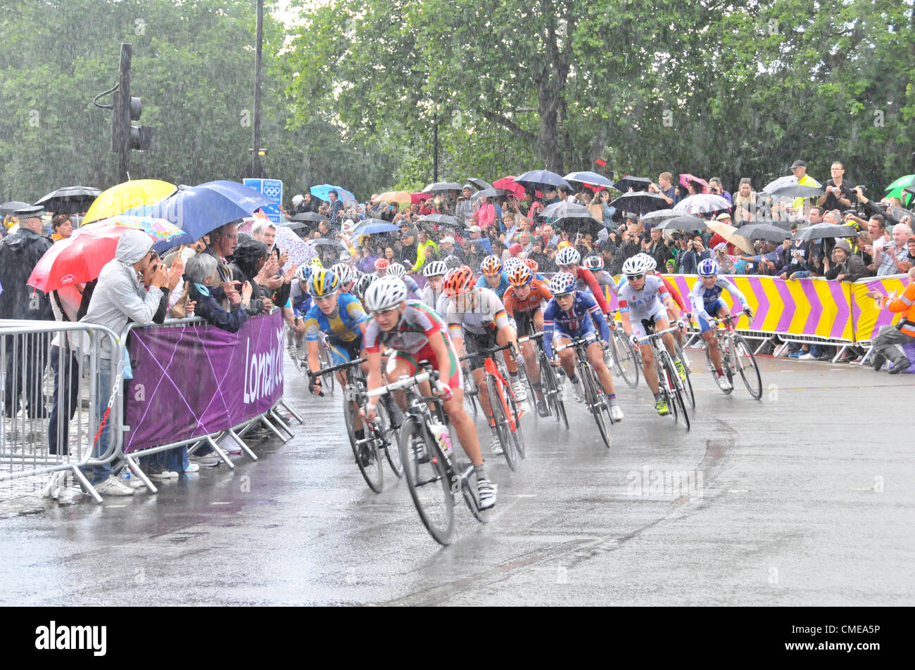 Hyde Park Corner, London, UK. 29th July 2012. The pack follows the leaders in the women's cycling road race at Hyde Park Corner approaches the end as the riders and crowd endure heavy rain and a thunderstorm. Stock Photo