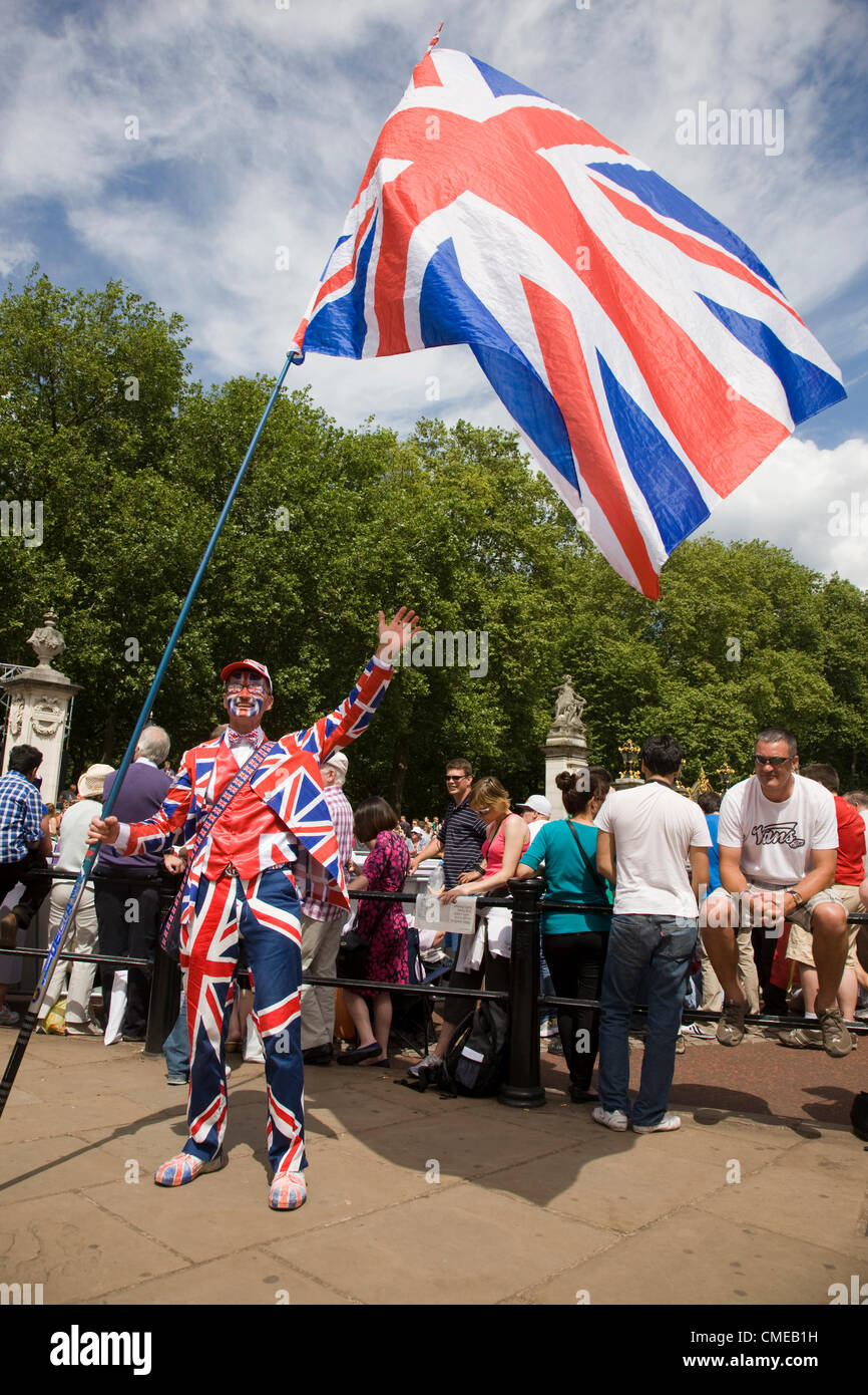 A man dressed in a Union Jack flag suit stands out from the crowd watching the Olympic cycling along the Mall Stock Photo