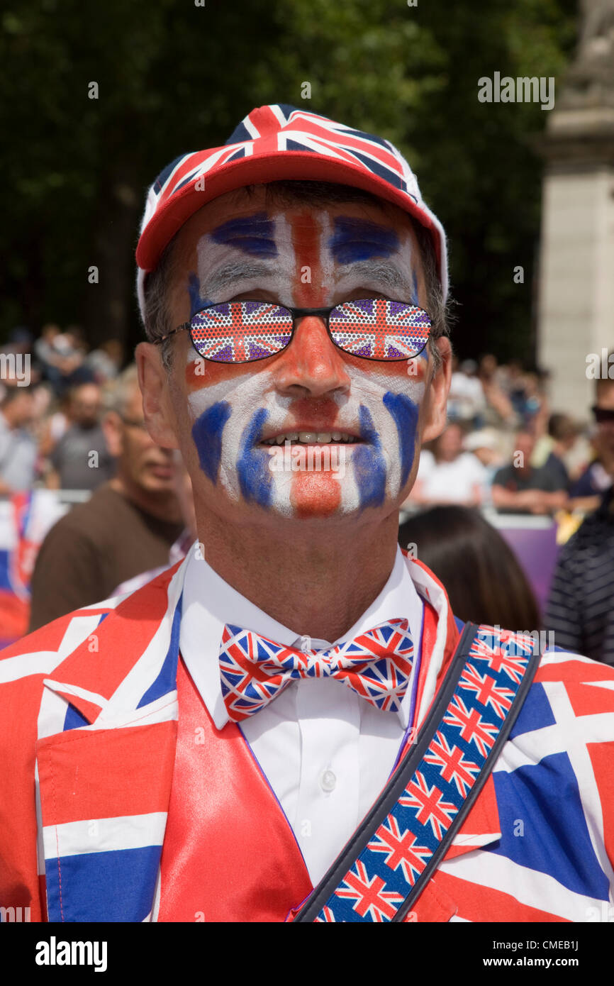A man dressed in a Union Jack flag suit stands out from the crowd watching the Olympic cycling along the Mall Stock Photo