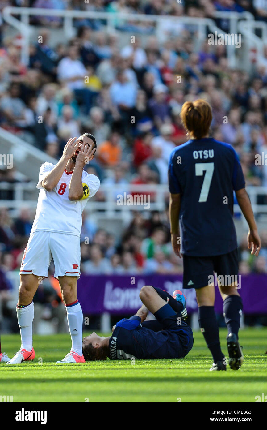 29.07.2012 Newcastle, England.  Driss Fettouhi (C) of Morocco covers his face after taking down Takahiro Ohgihara of Japan in action during the Olympic Football Men's Preliminary game between Japan and Morocco from St James Park. Stock Photo