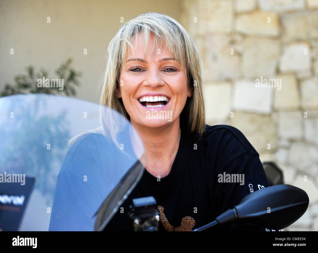 JOHANNESBURG, SOUTH AFRICA: Activist Zelda le Grange with her “baby” a grey silver and grey BMW 800SG motorbike during an interview on July 25, 2012 in Johannesburg, South Africa. She and some of South Africa’s popular personalities just returned from the third Biker 4 Mandela tour, which aims to raise money and help various charities countrywide. (Photo by Gallo Images / Foto24 / Loanna Hoffmann) Stock Photo