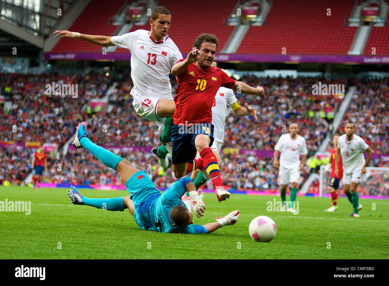 01.08.2012 Manchester, England. Spain midfielder Juan Mata, Morocco goalkeeper Mohamed Amsif and Morocco defender Zouhair Feddal in action during the third round group D mens match between Spain and Morocco at Old Trafford. Stock Photo
