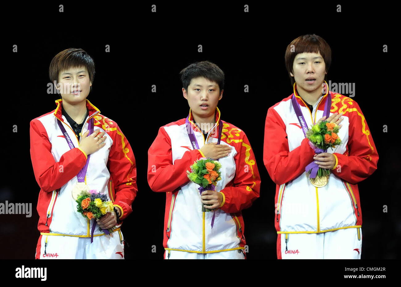 07.08.2012.  London, ENGLAND; Gold medalists Ding Ning, Guo Yue and Li Xiaoxia of China celebrate on the podium during the medal ceremony for the Women's Team Table Tennis on Day 11 of the London 2012 Olympic Games at ExCeL. Stock Photo