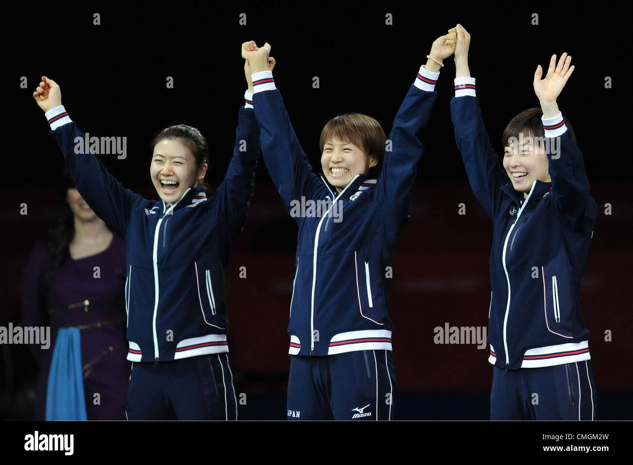 07.08.2012.  London, ENGLAND; (L-R) Silver medalists Ai Fukuhara, Sayaka Hirano and Kasumi Ishikawa of Japan celebrate on the podium during the medal ceremony for the Women's Team Table Tennis on Day 11 of the London 2012 Olympic Games at ExCeL. Stock Photo