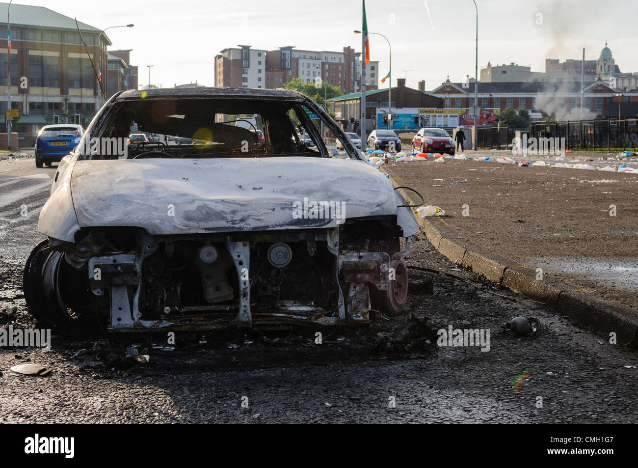 Belfast, Northern Ireland. 9th August, 2012. Burned out cars, stones and broken bottles litter Divis Street in West Belfast, after a night of disturbances at bonfires to commemorate the introduction of Internment in 1971. Stock Photo