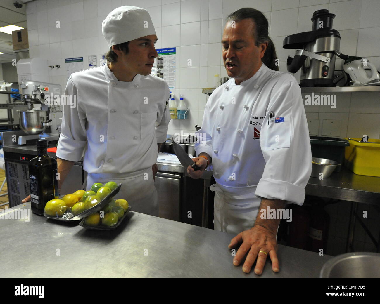 JOHANNESBURG, SOUTH AFRICA: Top Australian chef Neil Perry (R) on August 6, 2012 in the kitchen of the Level Four Restaurant of the 54 on Bath hotel in Johannesburg, South Africa. Perry got a better understanding of South African cooking styles during a cooking demonstration filmed for Australian television. (Photo by Gallo Images / Duif du Toit) Stock Photo