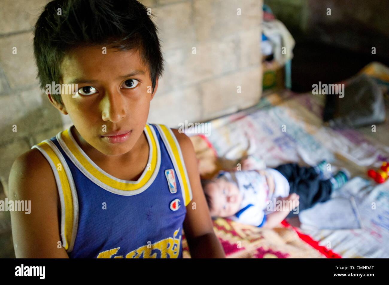 July 30, 2012 - El Palmar (Municipality, Quetzaltenango (Department, Guatemala - July 30, 2012, Quetzaltenango, Guatemala -  A young CRWRC beneficiary looks on as his nephew rests on the couch in the living room of the family house in the village of El Tineco, Guatemala. The family received agricultural support through a CRWRC training that helped them to increase their productivity on the small farm they rent in the community. (Credit Image: © David Snyder/ZUMAPRESS.com) Stock Photo