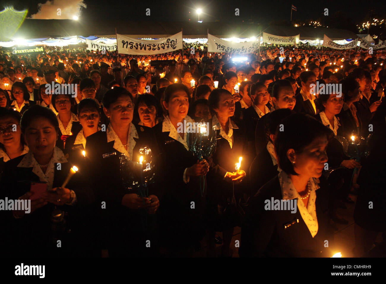 The Royal Field , Bangkok , Thailand , August 12 , 2012 .Thai people hold up a candles during a ceremony .Thais nationwide celebrate Her Majesty the Queen's 80th birthday with numerous celebrations and ceremonies. Stock Photo