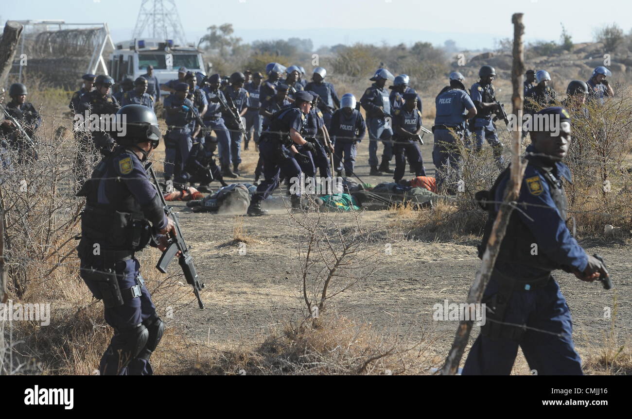 16th Aug 2012. RUSTENBURG, SOUTH AFRICA: Police officers open fire on striking mine workers outside the Nkageng informal settlement on August 16, 2012 in North West, South Africa. It is unclear how many workers were killed in the shooting. Violence broke out in the area as workers downed tools during an apparent wage strike. (Photo by Gallo Images / Foto24 / Felix Dlangamandla). Credit:  Gallo images / Alamy Live News Stock Photo