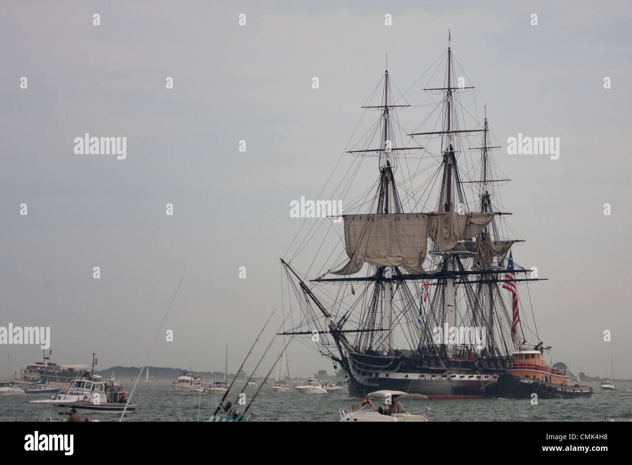 The USS Constitution is escorted through Boston Harbor after a